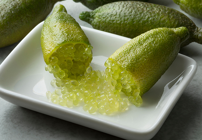 Halved fresh raw green finger lime caviar with sour pearls close up