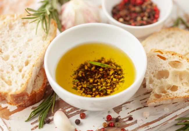 Olive oil herbal dip in a white bowl