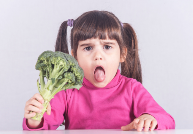 child turning up her nose at vegetables