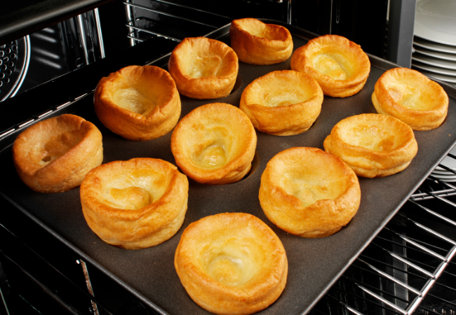 Individual Yorkshire puddings just coming out of the hot oven.